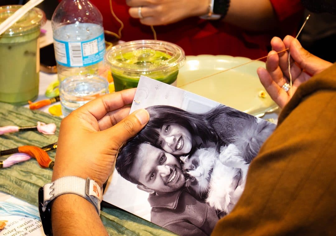 A printed photo held over the workshop table, ready to be stitched
